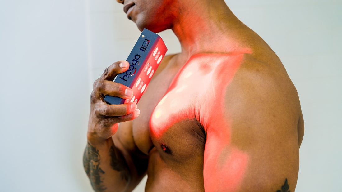 Man using the Hooga Charge red light therapy device on his shoulder