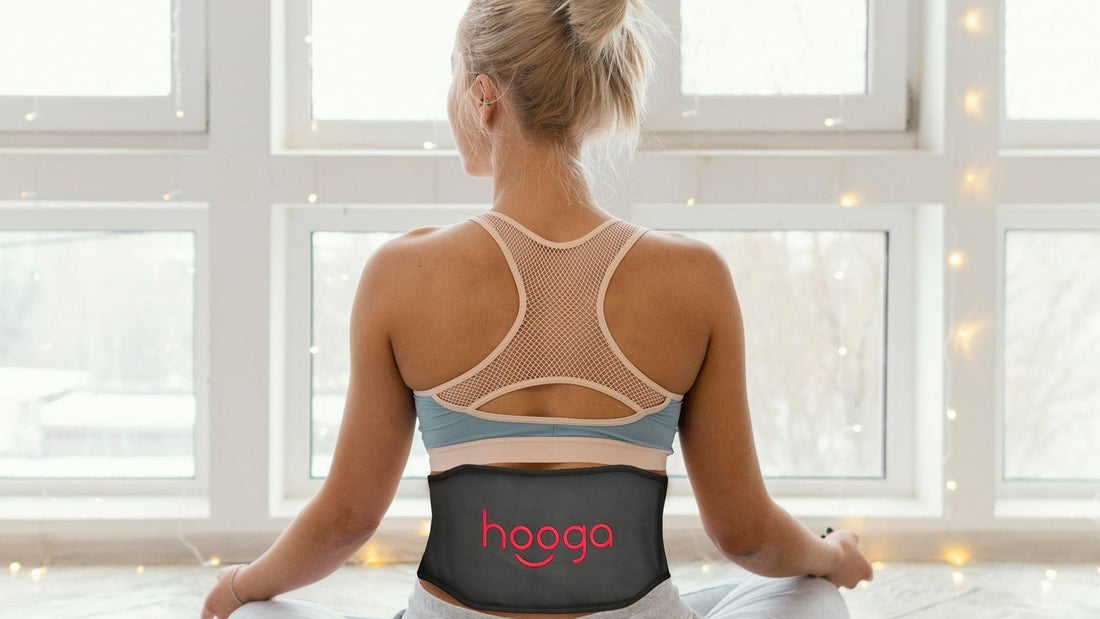 Woman wearing a Hooga red light therapy belt on her lower back