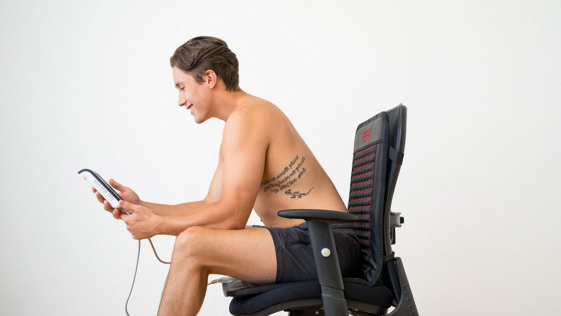 Man seated on a Hooga infrared PEMF chair mat