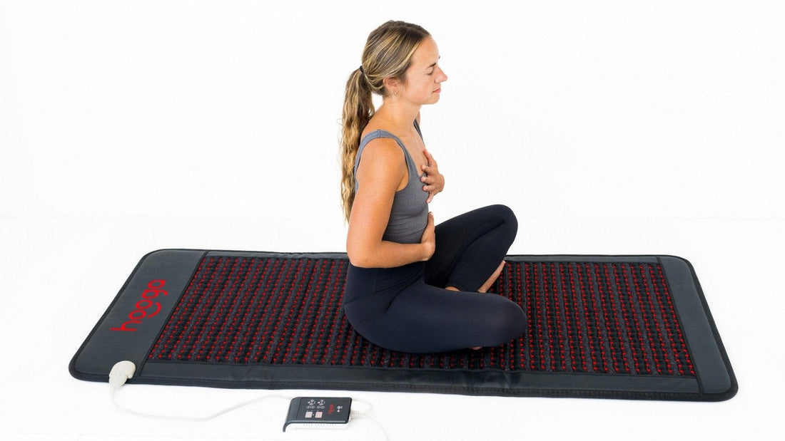 Woman sitting on a Hooga PEMF mat