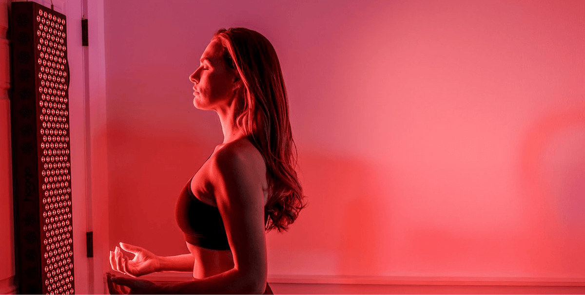 Person using a Hooga red light therapy panel at home